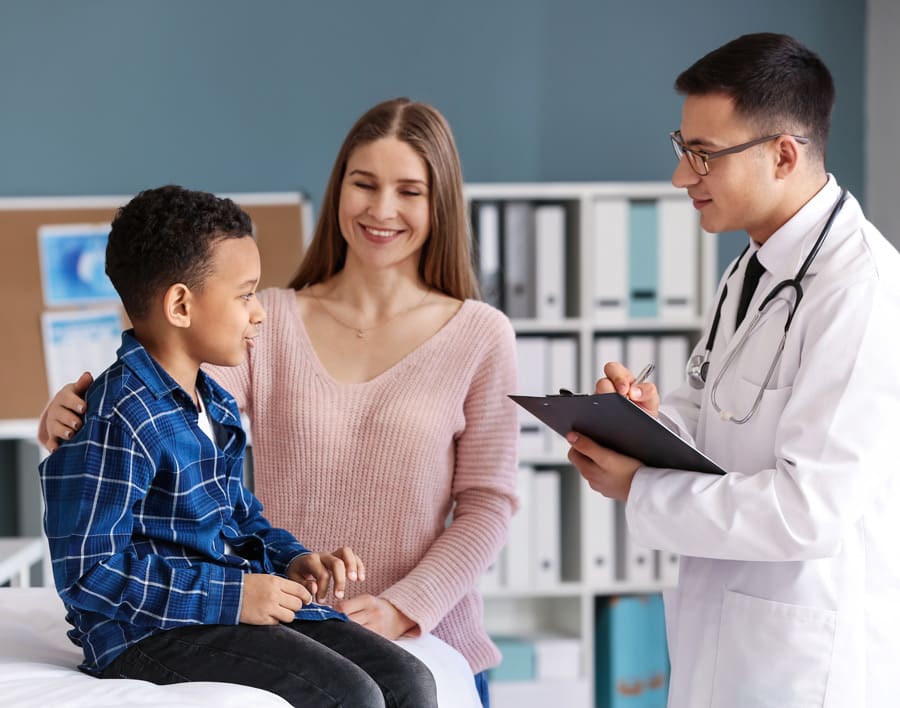 Doctor speaking with a mother and child in an examination room